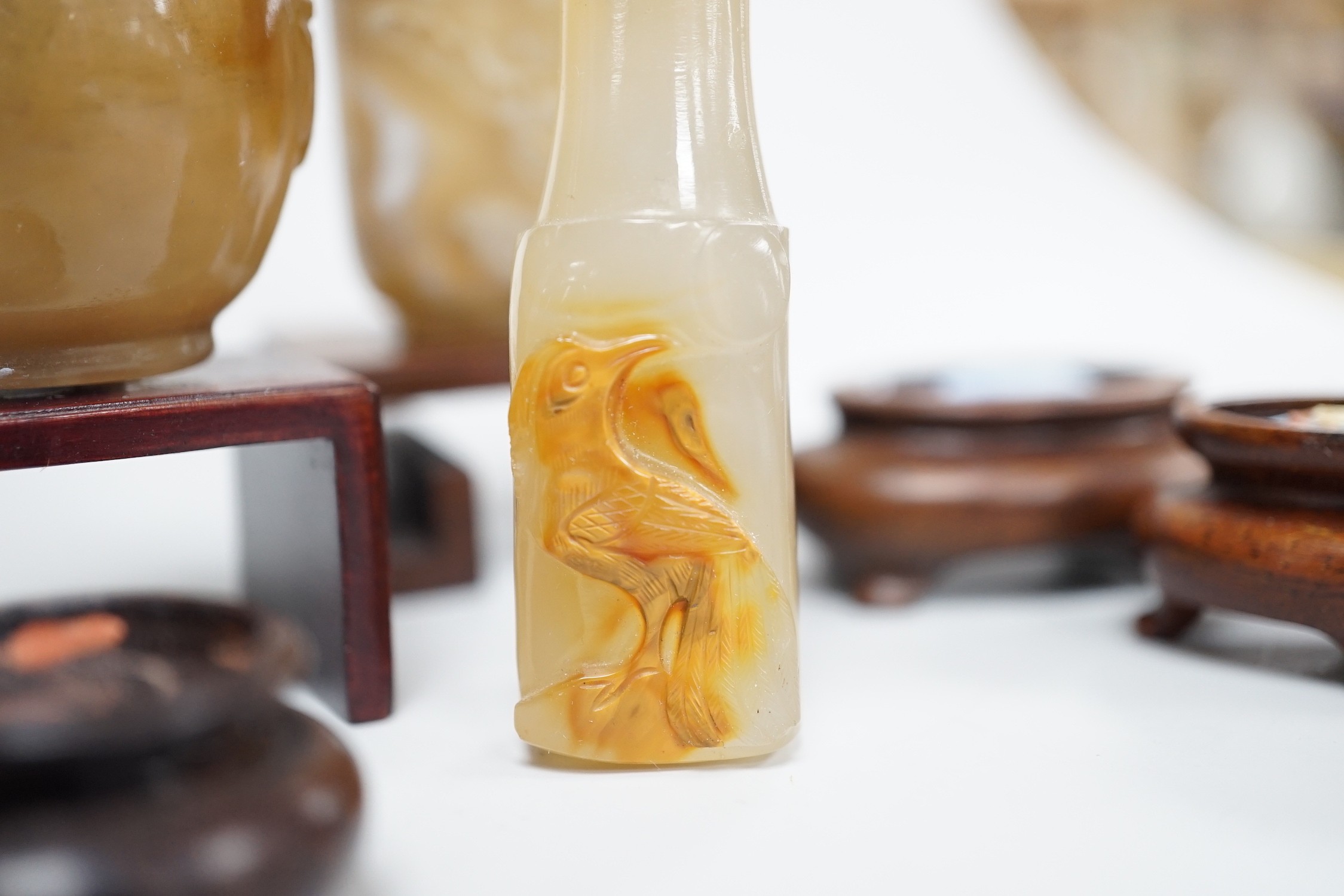 A Chinese chalcedony dendritic chalcedony (macaroni agate) snuff bottle, 5.7cm and a honey coloured agate mask and ring handled snuff bottle, 4.7cm, brass and coral stopper, both 1780-1880, together with a cameo agate pi